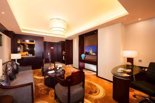 a living room with a couch and a table at New Century Grand Hotel Xi'an Xizang Building in Xi'an