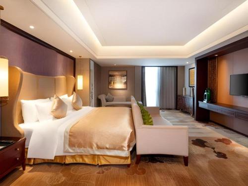 a large bedroom with a large bed and a television at New Century Grand Hotel Xi'an Xizang Building in Xi'an