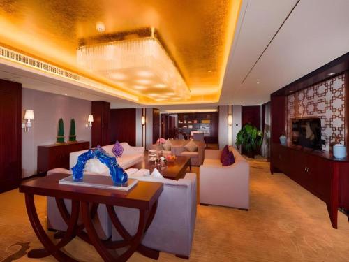 a living room with a couch and a table at New Century Grand Hotel Xi'an Xizang Building in Xi'an