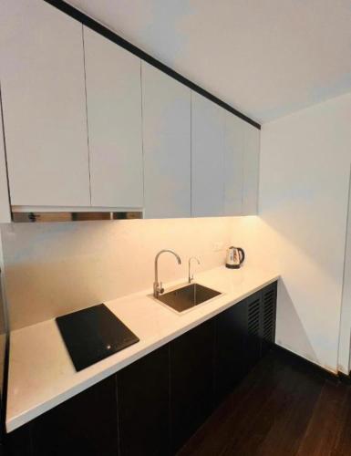 a kitchen with a sink and white cabinets at Homestay Sapphire S2 cho thuê theo giờ 2 tiếng in Ha Long