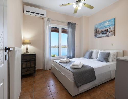 a bedroom with a bed with a view of the ocean at Han’s Maisonette in Porto Heli