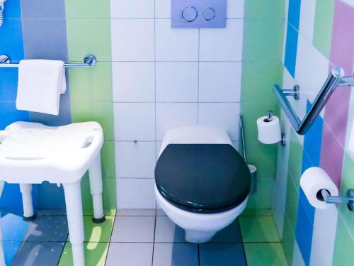 a bathroom with a black toilet and a sink at ibis Styles Montbéliard in Montbéliard