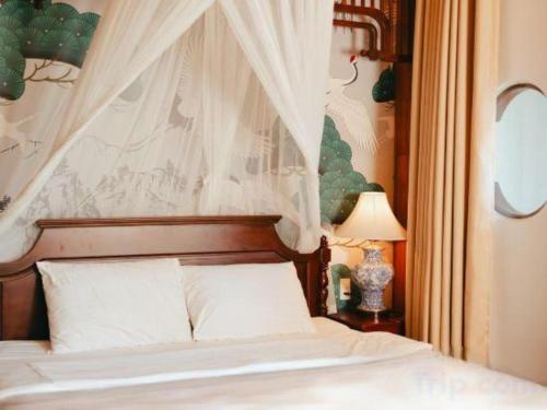 a bedroom with a white bed with a canopy at Jun's Home in Buon Ma Thuot