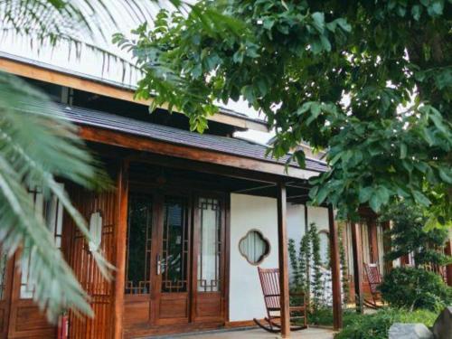 a house with wooden doors and a chair on the porch at Jun's Home in Buon Ma Thuot