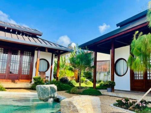 a house with a fountain in front of it at Jun's Home in Buon Ma Thuot