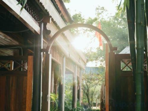 an arched doorway to a building with the sun shining through at Jun's Home in Buon Ma Thuot