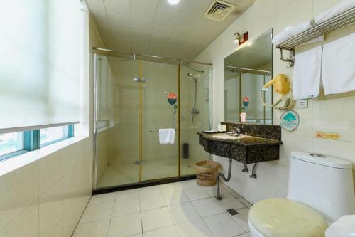 a bathroom with a shower and a sink and a toilet at GreenTree Inn GuangDong DongGuan HouJie Business Hotel in Dongguan
