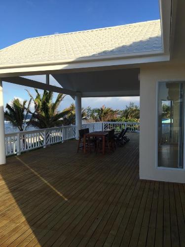 a deck with a table and chairs on a house at Seaside Beachfront Villas Rarotonga in Rarotonga