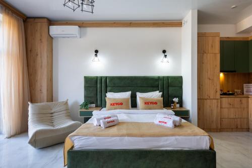 a bedroom with a large bed with a green headboard at Studio KeyGo #0058 near the Ararat Museum in Yerevan