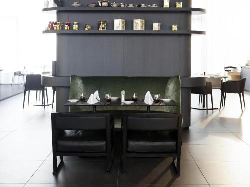 a dining room with a table and chairs in a restaurant at Novotel Basel City in Basel