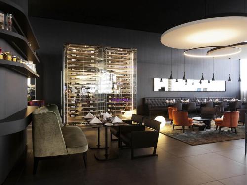 a restaurant with a dining room with tables and chairs at Novotel Basel City in Basel