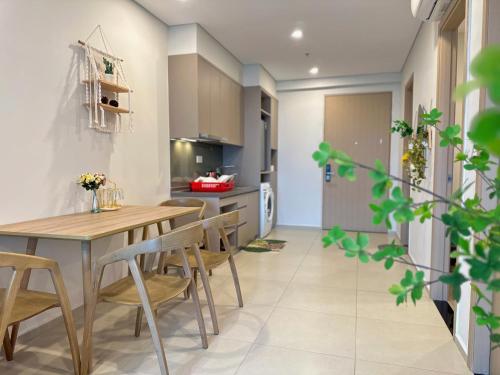a kitchen and dining room with a wooden table and chairs at The Song Boutique Aparment - Căn hộ Anh Kiet Home in Vung Tau