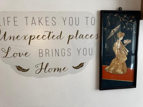 a sign hanging on a wall next to a picture at Cosy room in London Wembley in London