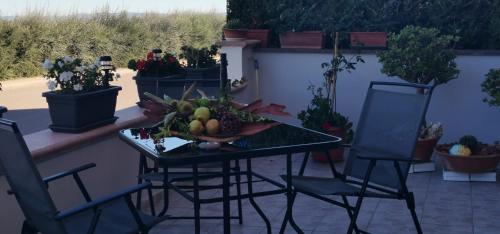 a table with a bowl of fruit and two chairs at Da Rita in Villanova Monteleone
