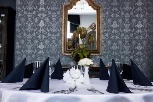 a table with blue napkins and utensils and a mirror at Pałac Domaniowski in Wieniawa