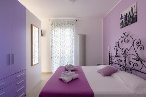 a bedroom with a purple bed with two stuffed animals on it at Appartamento Giglio in Numana