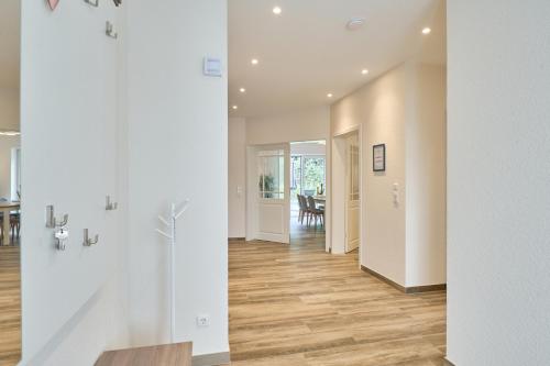 a hallway of a home with white walls and wood floors at Kanalkajüte Wilhelm in Hanerau-Hademarschen
