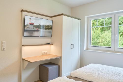 a bedroom with a desk and a window at Kanalkajüte Wilhelm in Hanerau-Hademarschen