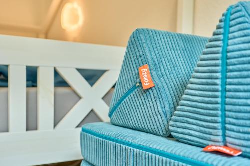 a blue couch with a red tag on it at Kanalkajüte Wilhelm in Hanerau-Hademarschen
