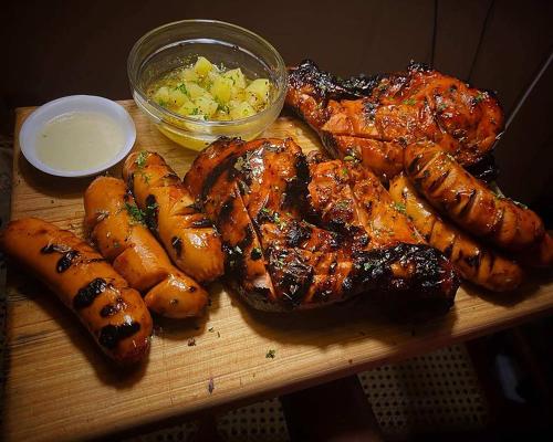 a cutting board with meat and potatoes and a bowl of sauce at Safaria Lodge Wilpattu in Pahala Maragahawewa