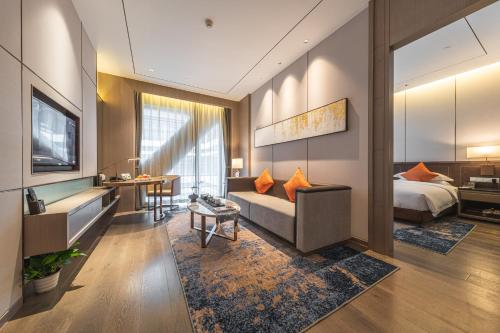 a hotel room with a bed and a living room at Changzhou Wenpu Hotel Changzhou Culture Square Branch in Changzhou