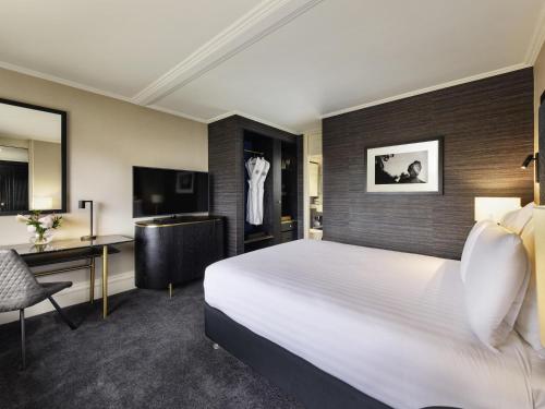 a hotel room with a bed and a desk at Pullman Auckland Hotel & Apartments in Auckland