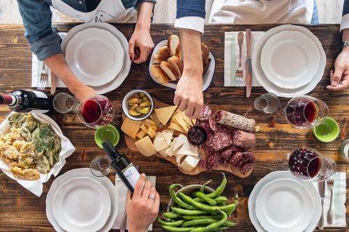 a group of people sitting at a table with food and wine at Villa Fiorenzani in Radicondoli