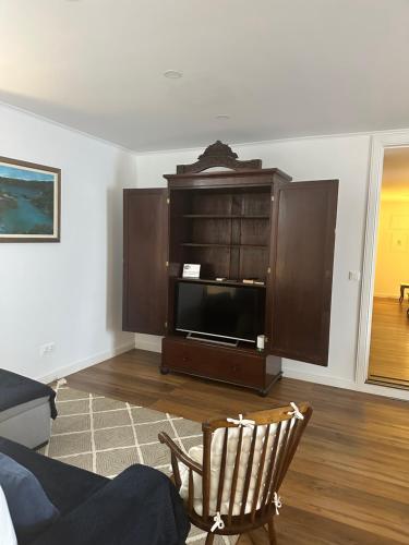 a living room with a entertainment center with a tv at Solar Nossa Senhora da Conceição in Capelas