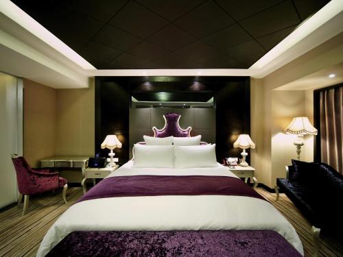 a bedroom with a large bed with a purple headboard at Pullman Guiyang in Guiyang