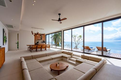 a living room with a couch and a table at Anzhu Seamate Villa Samui in Amphoe Koh Samui