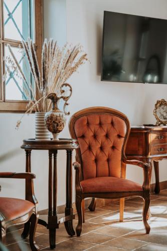 a chair and a table with a vase on it at Villa Serena in Siklós
