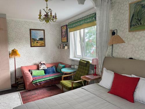a bedroom with a bed and a couch and a window at LITTLE LONDON boutique apartment with Netflix, top location in Old Town in Narva