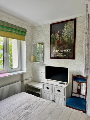 a bedroom with a bed and a flat screen tv at LITTLE LONDON boutique apartment with Netflix, top location in Old Town in Narva