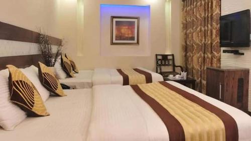 a hotel room with two beds and a television at Hotel Stay Well Dx in New Delhi
