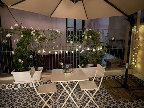 a table and chairs with flowers on a wall at FORTUNA Suite & Terrace in Salerno