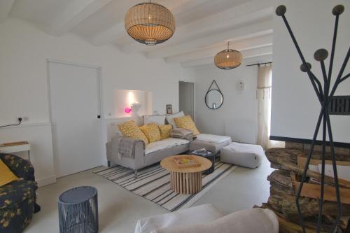 a living room with a couch and a table at Rénovation d'Architecte- Mer &Phare à pied in Saint-Clément-des-Baleines