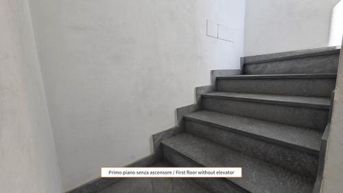 a staircase in a building with a sign that says first floor within cluster at Sugheri di mare - By Ligooria in Pietra Ligure