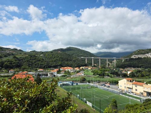 a tennis court in a city with mountains in the background at Sugheri di mare - By Ligooria in Pietra Ligure