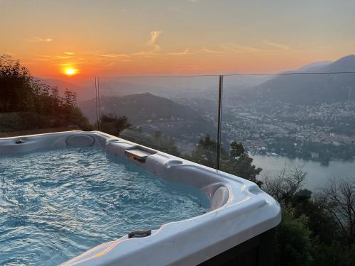 a hot tub with the sunset in the background at Baita Sorriso in Brunate