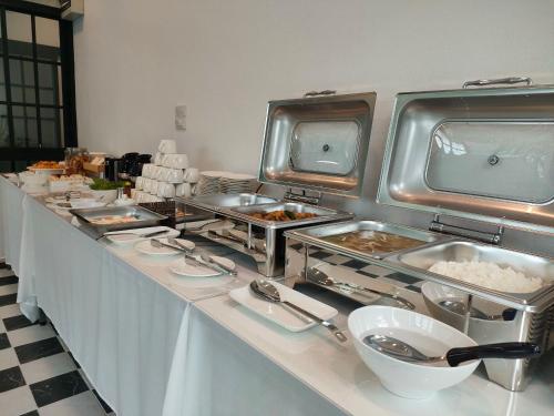 a buffet line with dishes of food on it at The Target Hotel chaingrai in Chiang Rai