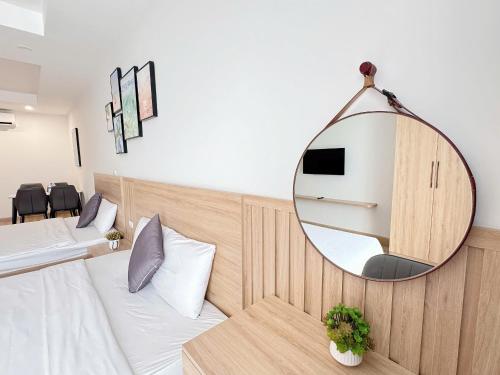 a room with a mirror on the wall and a bed at Seafront Apartment TMS Quy Nhơn in Quy Nhon