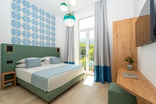 a bedroom with a bed and a large window at Domus Gualtieri in Sorrento
