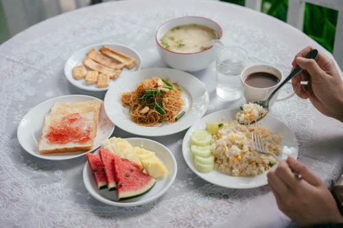 a white table with plates of food on it at The Target Hotel chaingrai in Chiang Rai