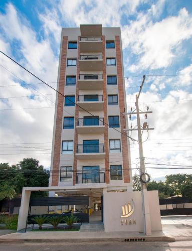 a tall building with a lot of windows at Cozy Apt Pool Plus CoWorking paraguay Deriv in Fernando de la Mora