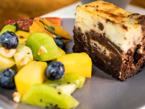 a plate of food with a piece of cake and fruit at Mercure Milano Agrate Brianza in Agrate Brianza