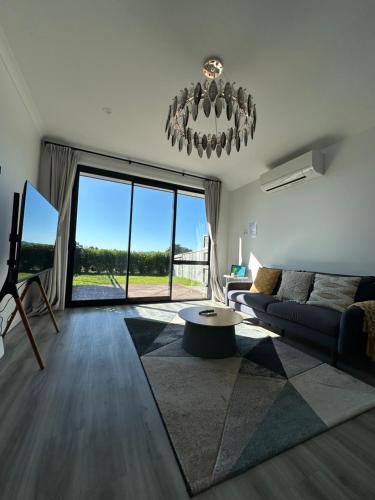 a living room with a couch and a large window at Paradise Retreat in Tauranga