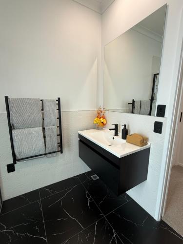 a bathroom with a sink and a mirror at Paradise Retreat in Tauranga