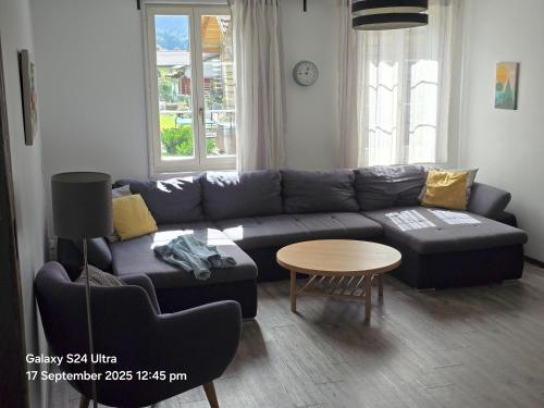 a living room with a couch and a table at Jungfrau Family Holiday Home in Matten