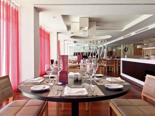 a dining room with a table with wine glasses at Hotel Mercure Braga Centro in Braga