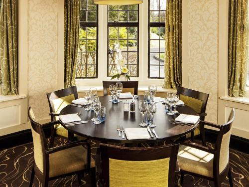 a dining room with a table and chairs and a window at Mercure Tunbridge Wells Hotel in Royal Tunbridge Wells